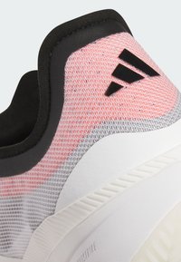 Scarpa sportiva con colletto imbottito nero, tomaia in mesh rosa e grigia e suola in gomma bianca. Presenta un logo in rilievo di colore nero.