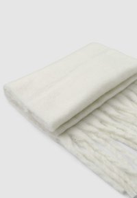 Biały szalik wykonany z miękkiego, puszystego materiału, z frędzlami na końcach i gładką strukturą; starannie złożony, ukazujący swój kształt.