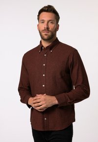 Camisa marrón de botones con una tela texturizada, cuello puntiagudo y botones blancos. Presenta un solo bolsillo en el pecho y mangas largas.