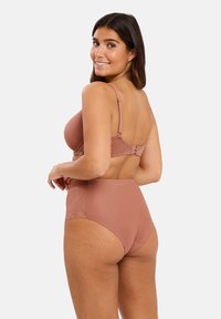 Ensemble soutien-gorge mauve et culotte taille haute avec des motifs géométriques texturés et des bretelles réglables, conçu pour le confort et une couverture complète.