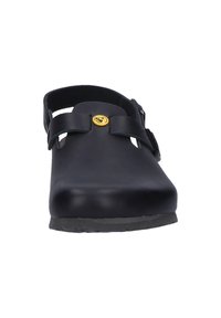Black clogs with a smooth, matte finish, adjustable strap, and a circular logo accent. Open back for easy wear. Textured sole for grip.