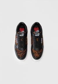 Juodi ir rudi leopardų rašto sportbačiai su balta padanga, su juodais raišteliais ir 'LOVE MOSCHINO' logotipu ant liežuvėlio bei šonų.