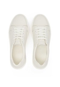 Zapatillas blancas con un exterior de cuero liso, puntera redondeada y diseño de cordones con seis ojales. Paneles laterales texturizados y una marca mínima.