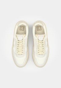 Sneakers bianchi in pelle con finitura texture, caratterizzati da accenti beige, lacci piatti e un logo sulla linguetta e sul lato.