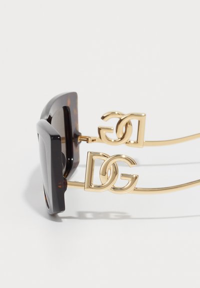 Black square-frame sunglasses with gold metal arms featuring intertwined "DG" logo accents on a white background.