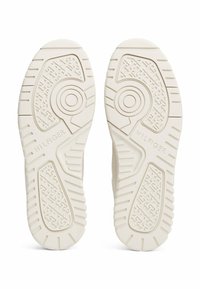 Weiße Gummisneakersohlen mit strukturierten Mustern, runden Akzenten und "HILFIGER"-Branding an der Außenseite.