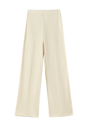 Kremfarvede bukser med vide ben i tekstureret vaflet strikstof og høj talje, lagt fladt på en hvid baggrund.