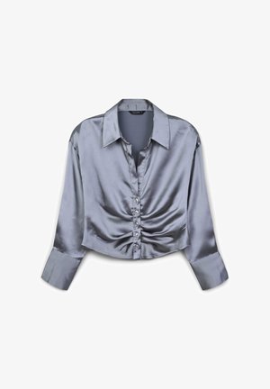 Long-sleeve, cropped, satin blouse in light gray with a buttoned front and gathered detailing at the waist. Features a classic collar and cuffed sleeves.
