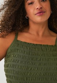 Groen gesmokt tanktop met dunne bandjes, met een textuurontwerp van horizontale plooien en zachte, lichte stof.