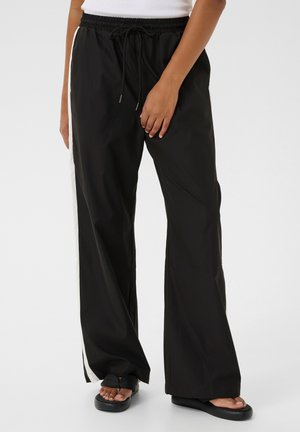 Black wide-leg pants with an elastic waistband and drawstring. Features a white side stripe. Fabric appears smooth and lightweight.