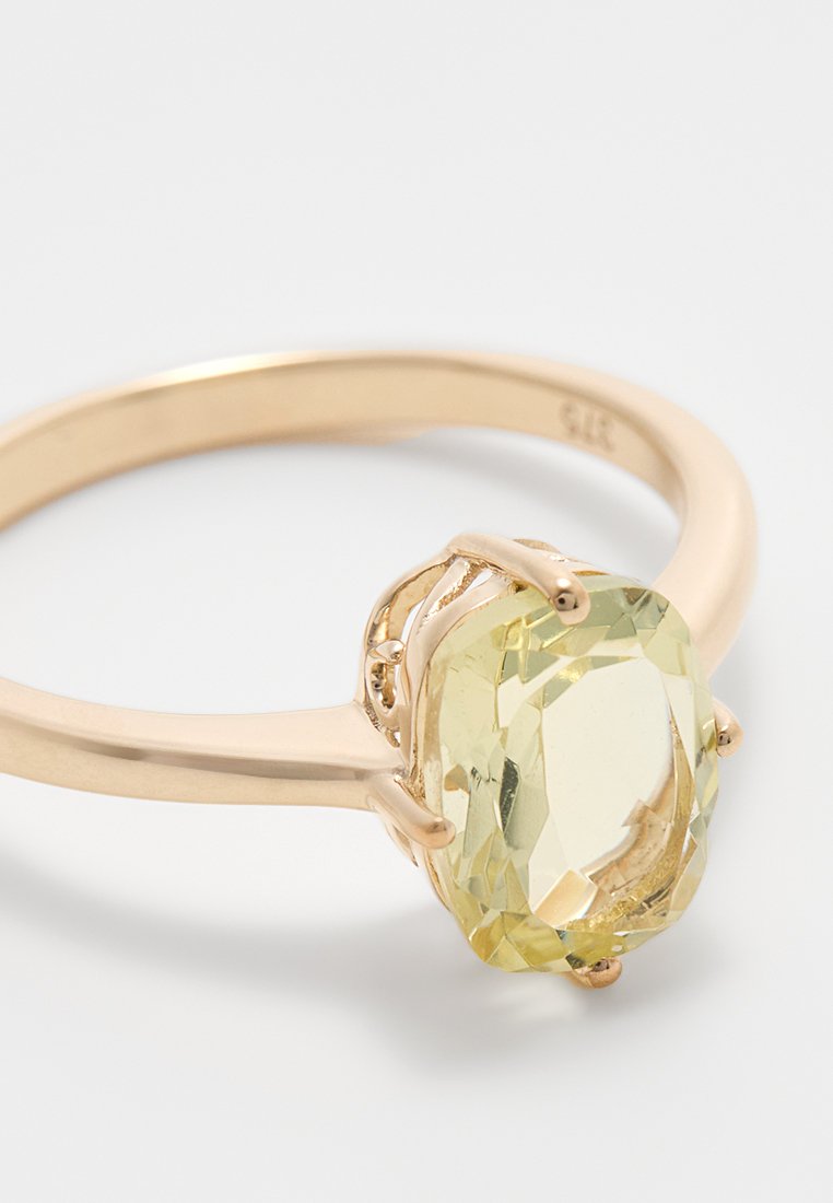 Goldring mit einem ovalen, hellgelben Edelstein, der in einer detaillierten Krappenfassung eingesetzt ist; glatter Band mit polierter Oberfläche.