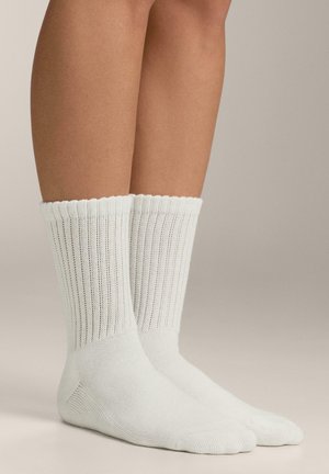 Light white cotton socks with ribbed texture, featuring a scalloped cuff and reinforced toe and heel areas.