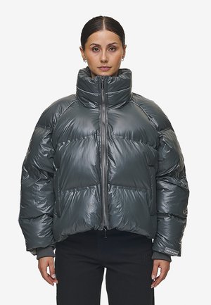 Donkergrijze pufferjack met een hoge hals, volledige ritssluiting aan de voorkant en elastische manchetten. Heeft een glanzende afwerking en een gewatteerd ontwerp.