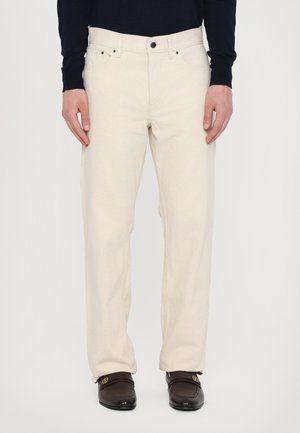 Beige cotton trousers with a straight leg design. Features a button and zipper closure, belt loops, and side pockets. Smooth texture.