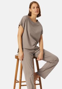 Lichtgrijze lounge-outfit van zachte stof. Het T-shirt met korte mouwen heeft een ontspannen pasvorm; de bijpassende broek heeft een rechte snit met subtiele zijnaad.