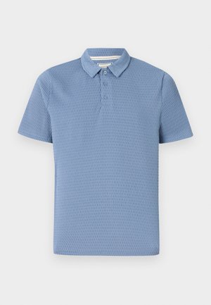 Polo de cor azul clara com um tecido texturizado, mangas curtas, fecho de três botões e colarinho clássico. Design simples e clean.