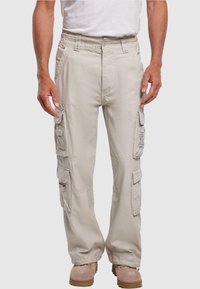 Pantalones cargo beige con múltiples bolsillos laterales, cintura elástica y diseño de pierna recta, confeccionados en tejido ligero.