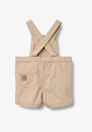 Pantaloncini beige per bambini piccoli con bretelle incrociate e una piccola tasca posteriore con toppa logo cucita.