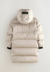 Giacca puffer beige chiaro con cappuccio, caratterizzata da un design trapuntato, dettagli neri sulle maniche e un'etichetta con la scritta "BAKER" sul retro.