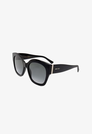 Occhiali da sole oversize neri a forma di occhi di gatto con lenti sfumate scure e logo Jimmy Choo in oro sulla stanghetta, esposti su sfondo bianco.