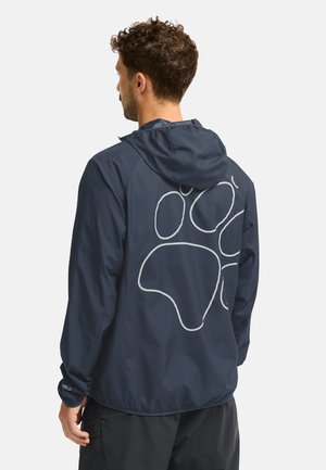 Giacca impermeabile blu navy con cappuccio, polsini elastici e un distintivo motivo astratto bianco sulla schiena. Design leggero e traspirante.