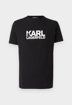 Melna kokvilnas T-krekls ar drosmīgu baltu "KARL LAGERFELD" logotipu priekšpusē, apaļa kakla izgriezums un īsas piedurknes. Gluda tekstūra un klasiskas formas.