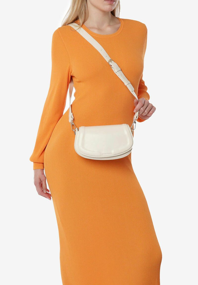 Borsa a tracolla bianca realizzata in materiale morbido, caratterizzata da una forma curva, cuciture sottili e una tracolla removibile.