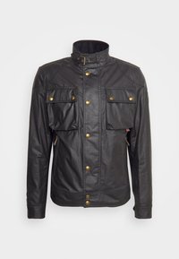 Svart läderjacka med hög krage, fyra framfickor med mässingsknappar och en dragkedjedetalj på sidan. Tydlig textur.