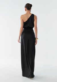 Melnas satīna maksi kleitas ar vienu plecu, elastīgu vidukļa joslu un plūstošu siluetu. Iespējas ar gludu tekstūru un grīdas garuma apdari.