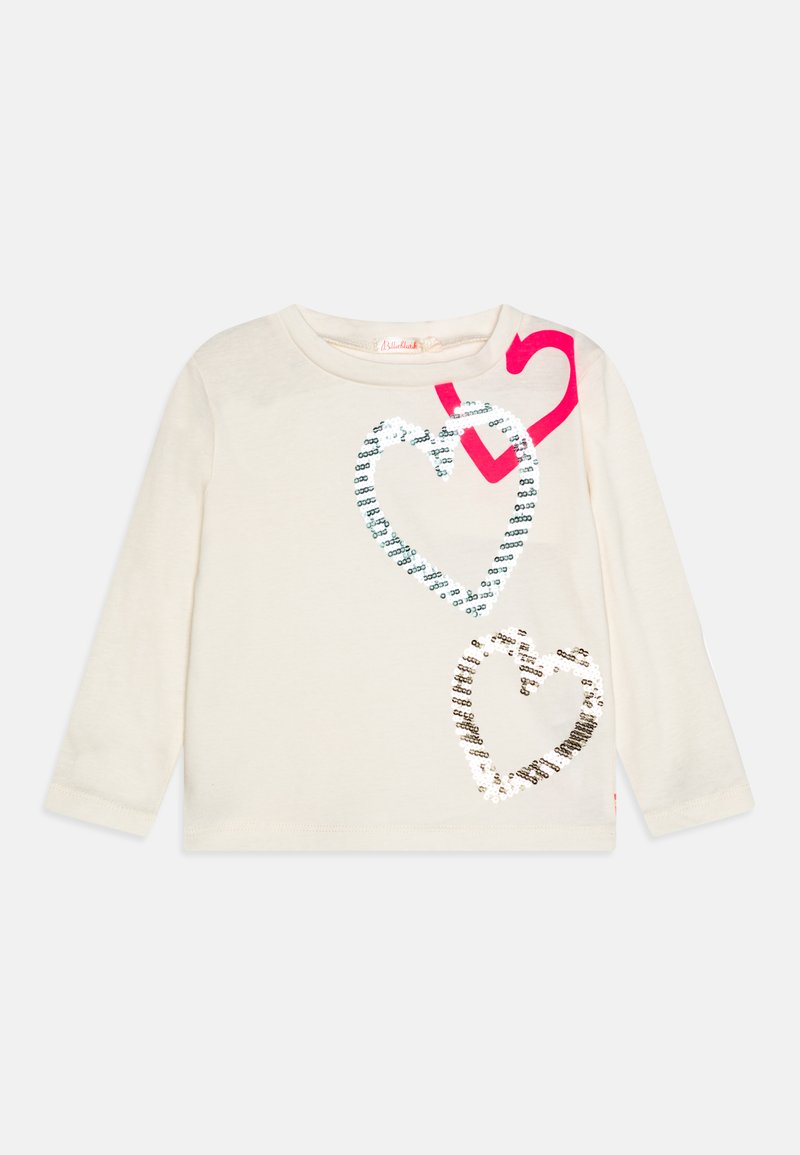 Top crema a maniche lunghe con tre cuori in paillettes argento, acquamarina e rosa, e un audace accento a forma di cuore rosa vicino alla spalla.