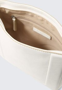 Borsa cosmetica bianca testurizzata con chiusura a zip, dotata di una fodera interna liscia e di una piccola tasca interna con zip, di forma rettangolare.
