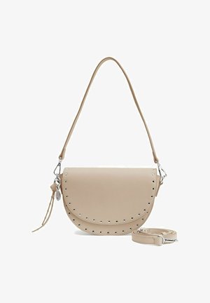 Beige schoudertas van glad materiaal, met een halve maan vorm, zilveren studs langs de rand en een afneembare schouderriem. Accenten van zilverkleurig metaal.