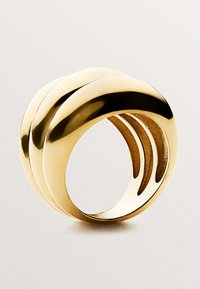 Anillo de oro con una superficie lisa y pulida, que presenta tres bandas entrelazadas, mostrando un diseño redondeado y recortes abiertos para un detalle adicional.