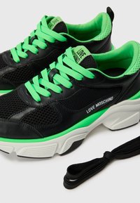 Zwarte mesh en leren sneakers met felgroene veters en accenten. Heeft een witte tussenzool en "LOVE MOSCHINO" branding aan de zijkant.