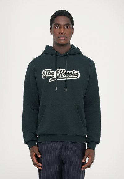 Un hoodie vert foncé avec une poche kangourou à l'avant et le texte du logo blanc "The Kooples" sur la poitrine. Tissu doux avec des cordons de serrage réglables.