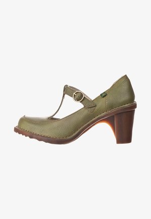 Chaussure Mary Jane en cuir vert avec un bout rond, une sangle ajustable et un talon en bois ; présente une finition texturée et des coutures contrastantes.