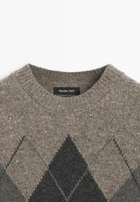 Maglione grigio a maglia con motivo a rombi scuri e scollatura a girocollo a coste, con etichetta nera Massimo Dutti all'interno del colletto.