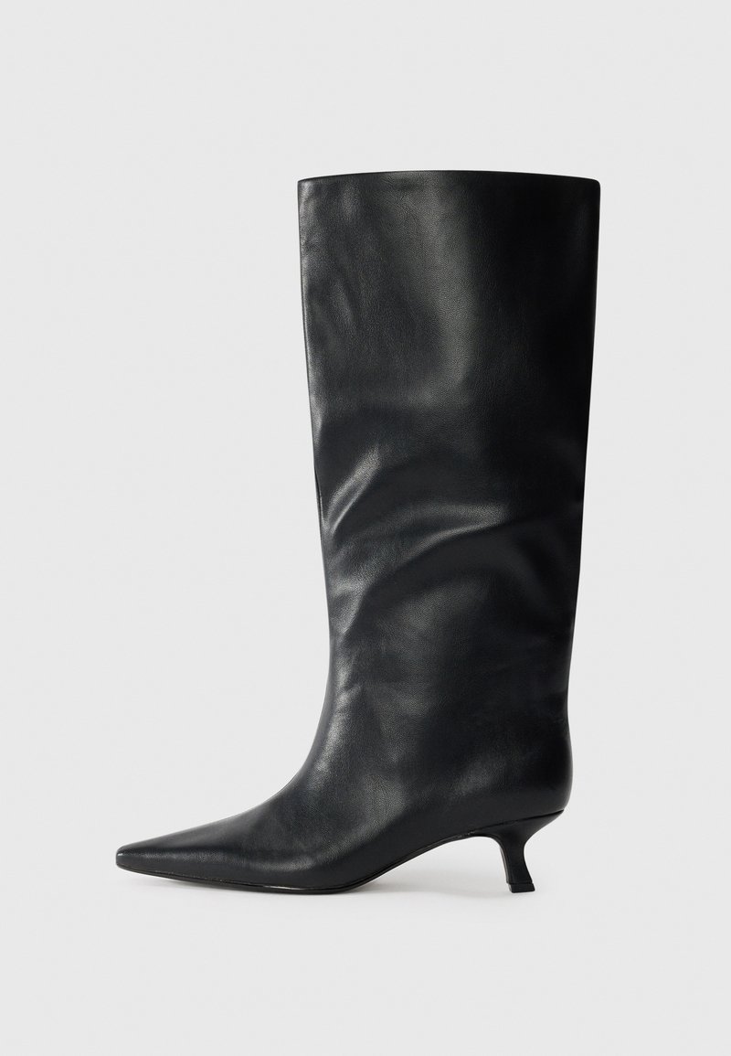 Black knee-high leather boot with pointed toe and low kitten heel, displayed on a plain light background.