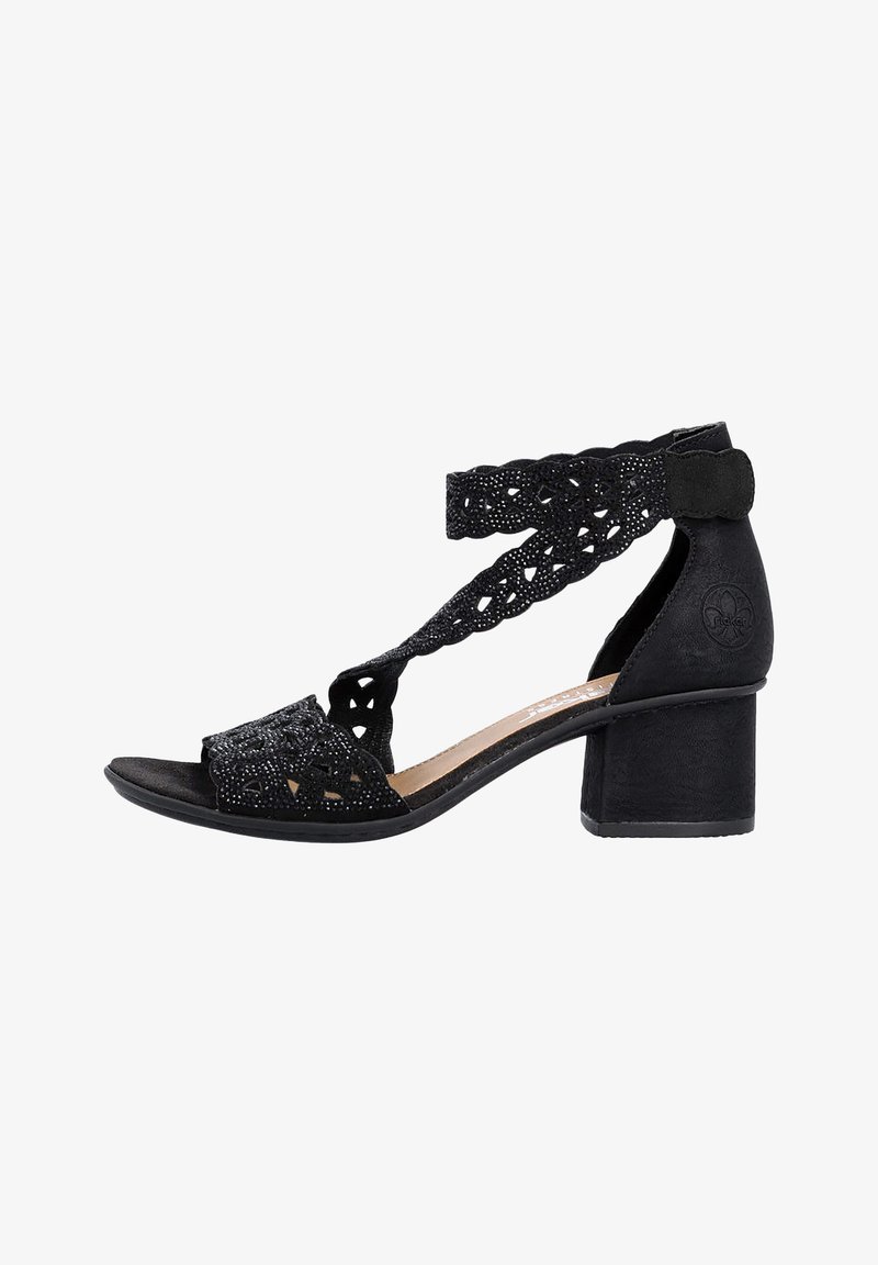 Sandale noire à bout ouvert avec talon bloc, ornée de brides décoratives découpées au laser et perles autour de la cheville et du pied avant.