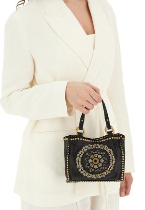 Borsa in pelle nera con embellishments metallici circolari, borchie dorate e doppi manici. Superficie testurizzata e dettagli decorativi.