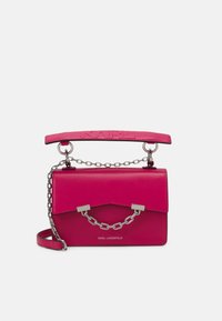 Różowa skórzana torebka o usztywnionej konstrukcji, z metalowymi akcentami w postaci łańcucha oraz wyraźnym uchwytem u góry. Posiada wytłoczone logo na uchwycie.