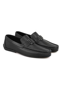 Schwarze Lederloafers mit Riemen und Schnallendetails, glatte Textur, flaches Profil und flexible Sohle. Ideal für Smart-Casual-Outfits.
