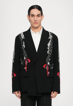 Schwarzer doppelt geknöpfter Blazer mit komplizierten silbernen und roten Stickereidetails an den Ärmeln. Glatter Stoff mit strukturierter Silhouette und Taschen.