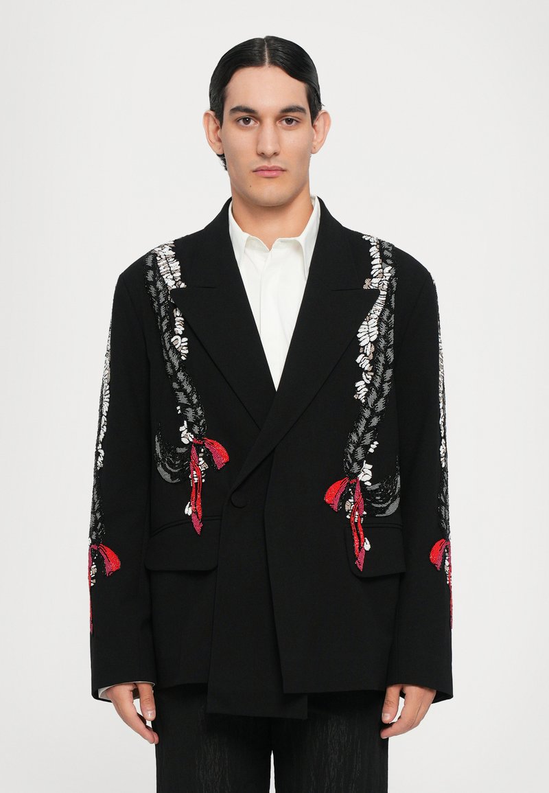Schwarzer doppelt geknöpfter Blazer mit komplizierten silbernen und roten Stickereidetails an den Ärmeln. Glatter Stoff mit strukturierter Silhouette und Taschen.