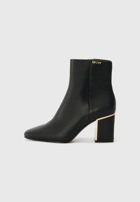 Black leather ankle boot with pointed toe and gold-accented chunky heel. Zip closure at the back, smooth texture, sleek design.
