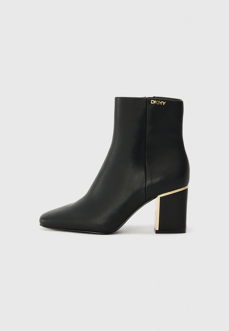 Black leather ankle boot with pointed toe and gold-accented chunky heel. Zip closure at the back, smooth texture, sleek design.