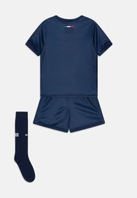Navy athletic jersey with short sleeves and matching shorts, made of lightweight fabric; includes knee-high socks with “PARIS” logo.