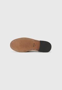 Talpa de pantof din piele bronzată, cu o culoare naturală și toc negru, margini cusute și imprimat al brandului pe interiorul tălpii.