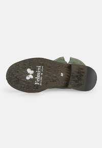 Suela de zapato de gamuza verde con textura de madera, tacón negro y detalle de costura. Presenta un logo en relieve y tamaño 37.