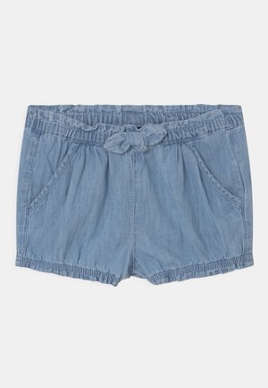 Shorts en denim bleu clair avec taille élastique, poches avant et un nœud en tissu noué au centre.